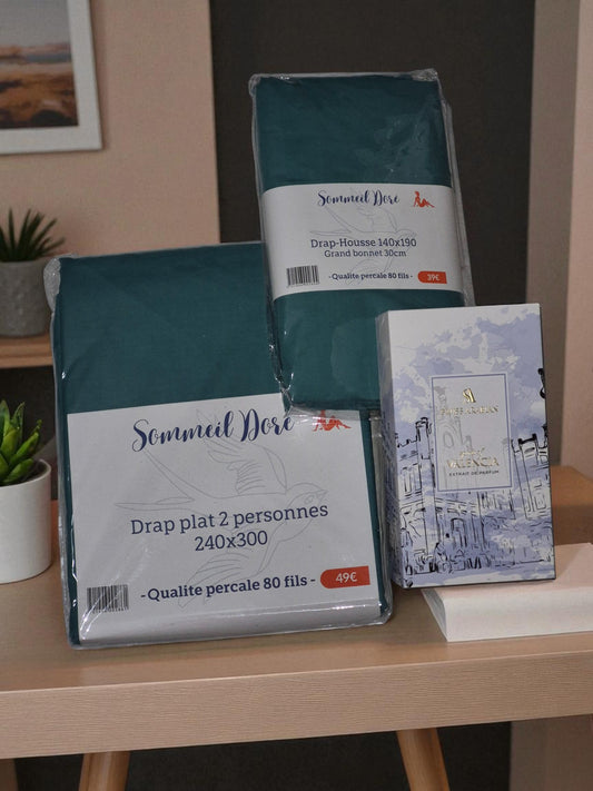 Coffret de linge de lit vert canard Sommel Douceur avec drap plat et drap housse, présenté sur une table en bois.