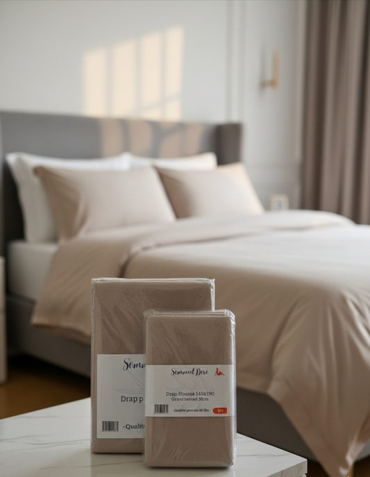 Ensemble de draps en coton percale beige clair avec housse et drap plat, linge de lit doux et élégant posé sur un lit