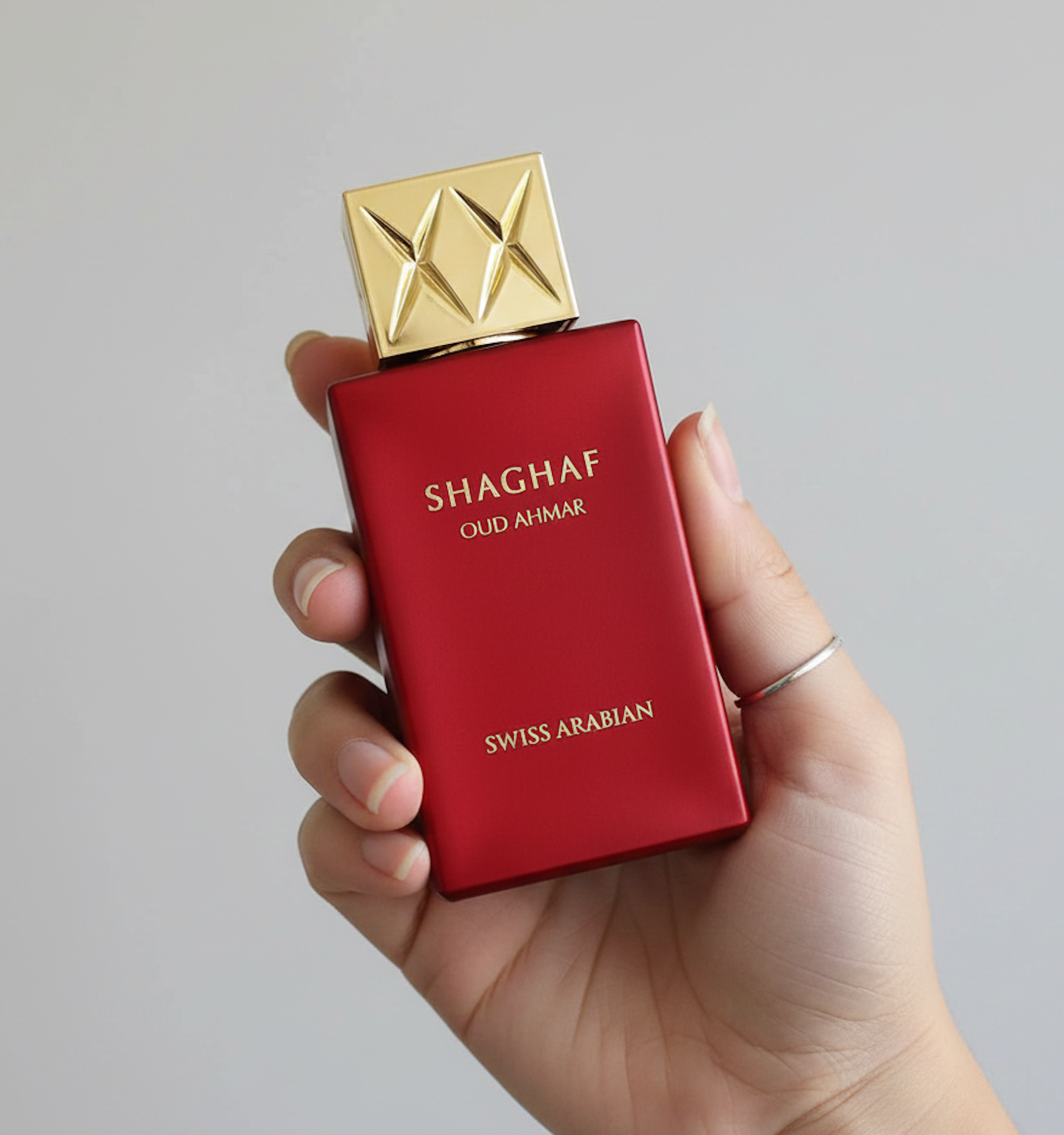 alt="Parfum Shaghaf Oud Ahmar tenu dans une main, mettant en valeur le flacon"