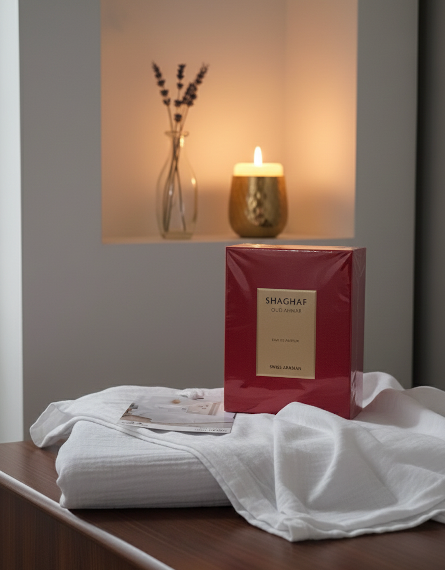 Parfum Shaghaf Swiss Arabian dans son coffret rouge avec bougie et lavande, éclairage chaud et atmosphère raffinée